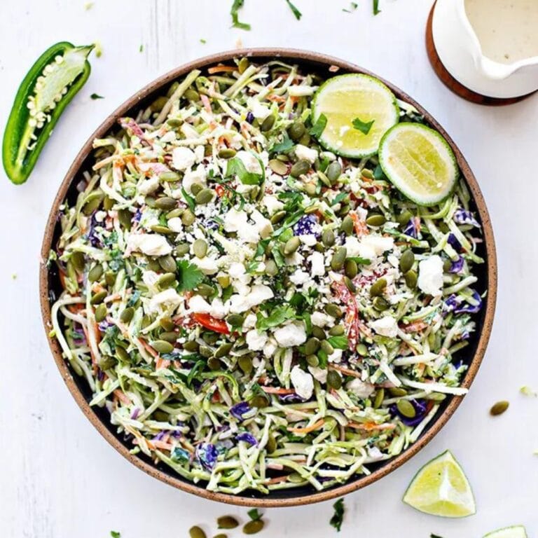 Cilantro Lime Broccoli Slaw in a serving bowl garnished with jalapeno, lime and cilantro.