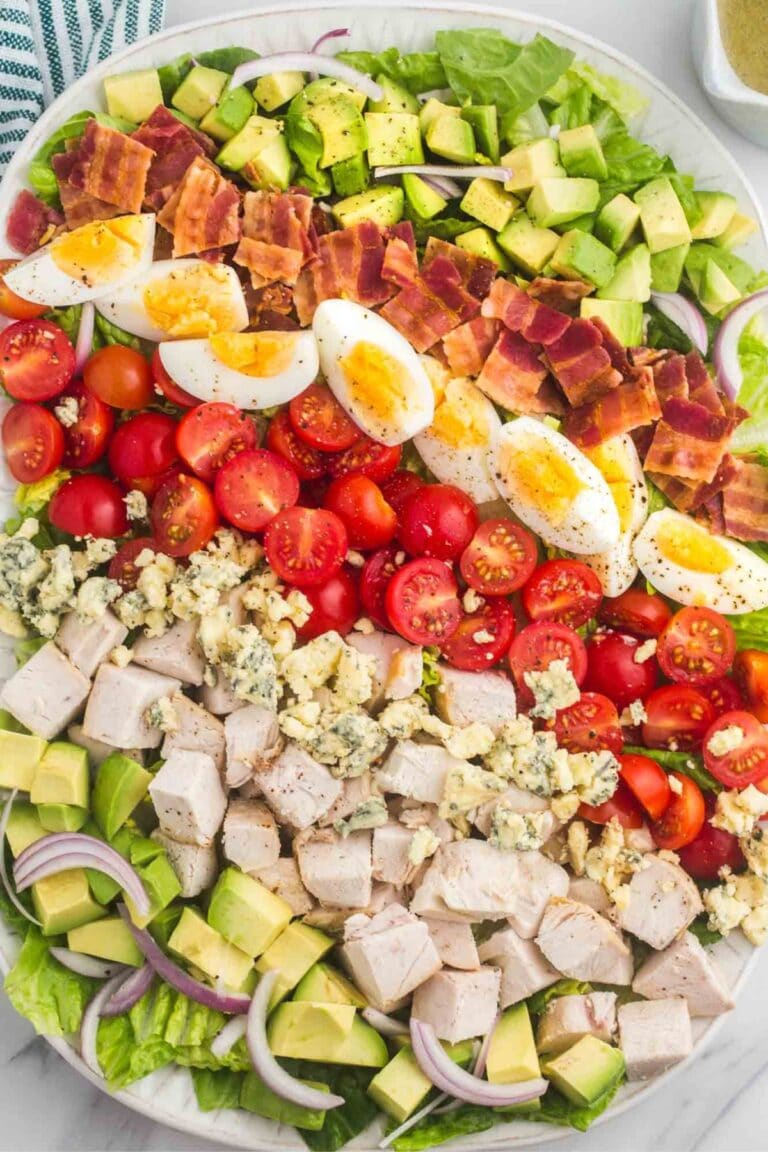Cobb salad with the ingredients arranged in rows on a large serving platter.