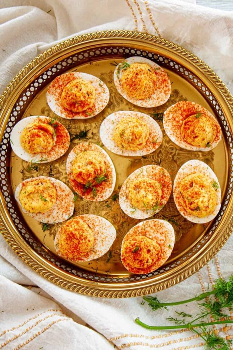 Dill pickle spicy deviled eggs on a gold platter.