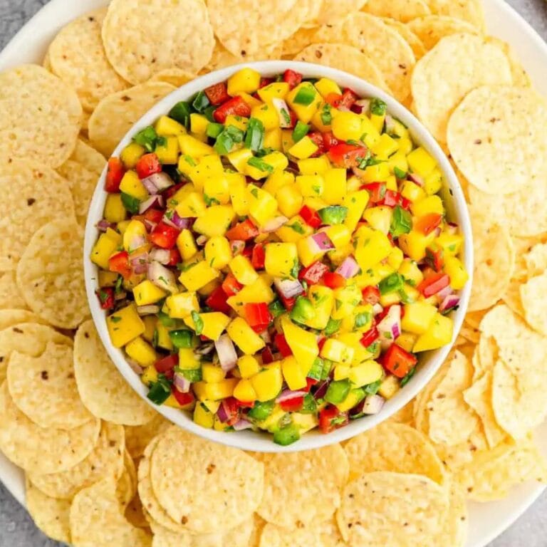Bowl of Mango Pico de Gallo surrounded by tortilla chips.