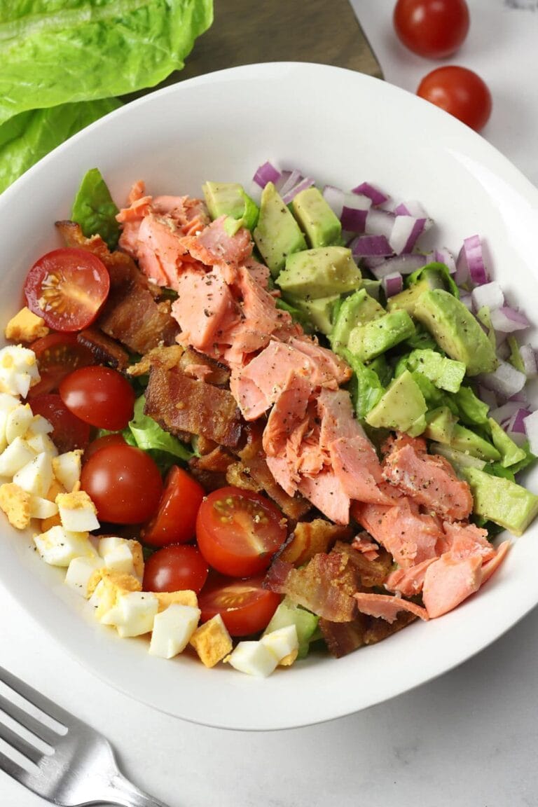 Salmon Cobb Salad in a white bowl with fork.