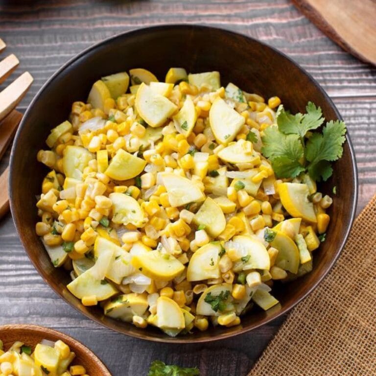 A bowl of summer squash and corn with green chili peppers.