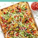 Sheet pan of vegetarian nachos with text overlay that reads "Loaded Veggie Nachos".