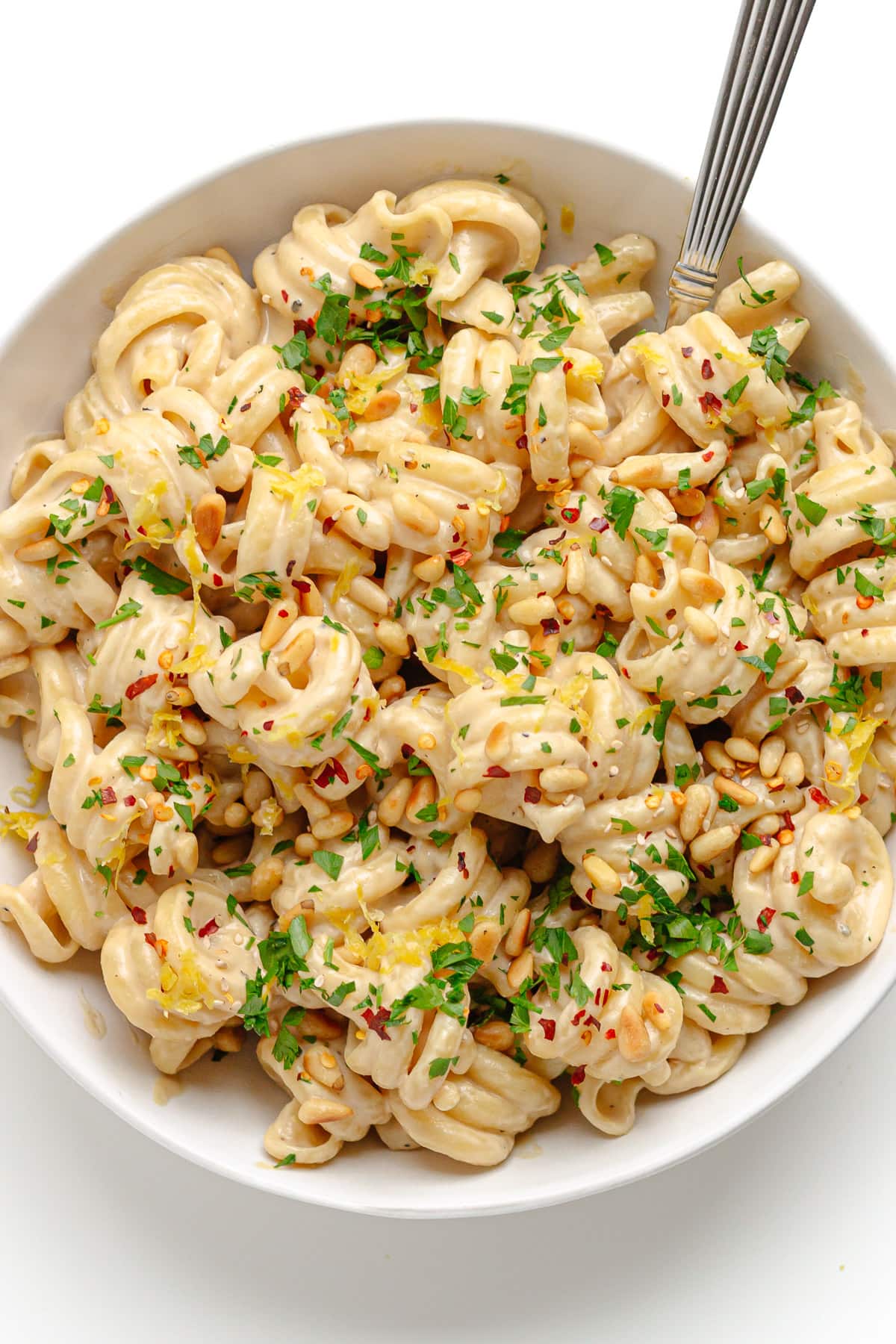 Tahini pasta in white bowl with fork.