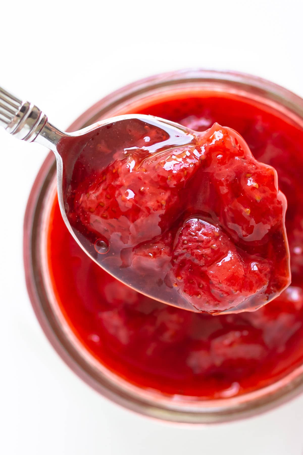 Overhead of spoonful of homemade strawberry topping.