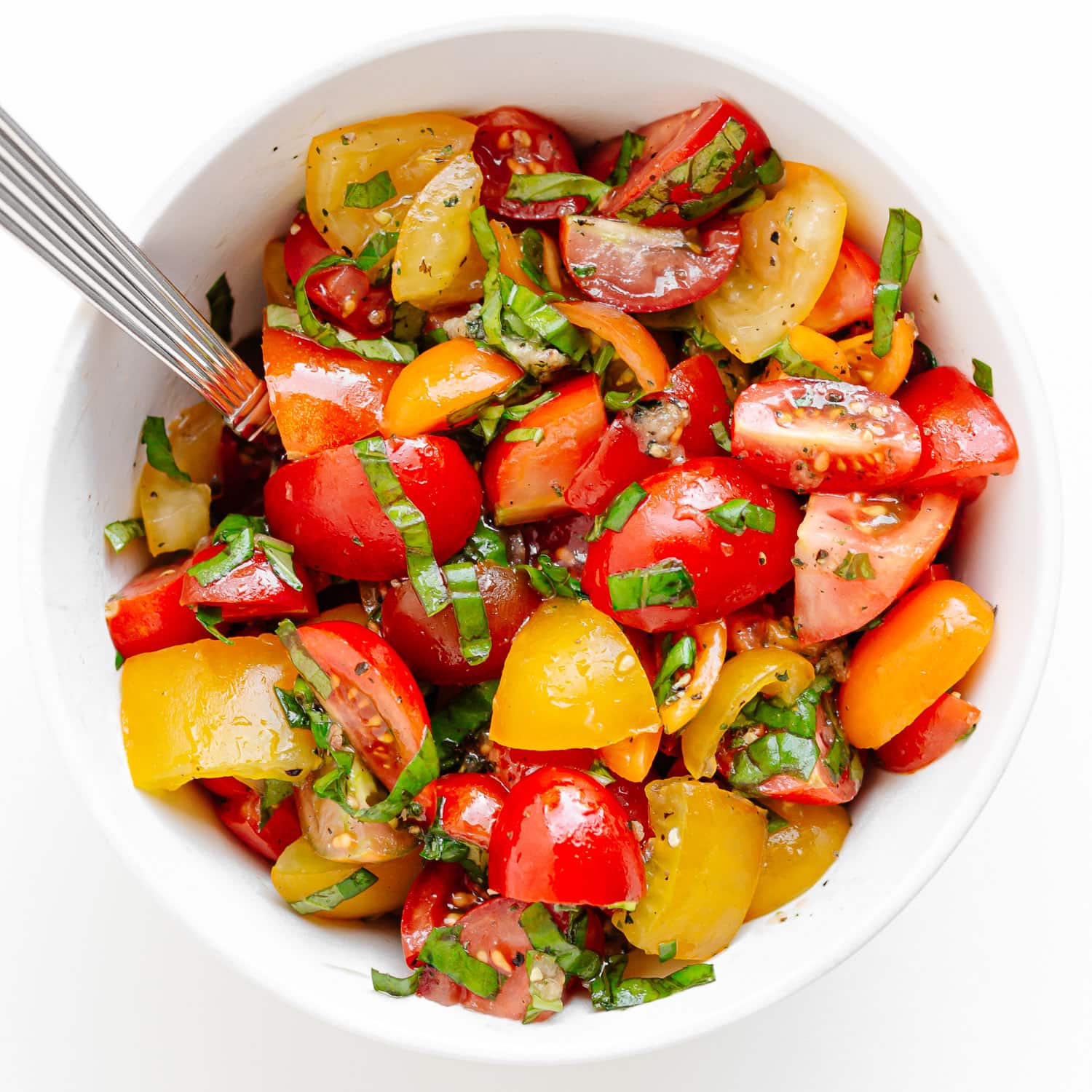 Marinated tomato basil topping in white bowl.
