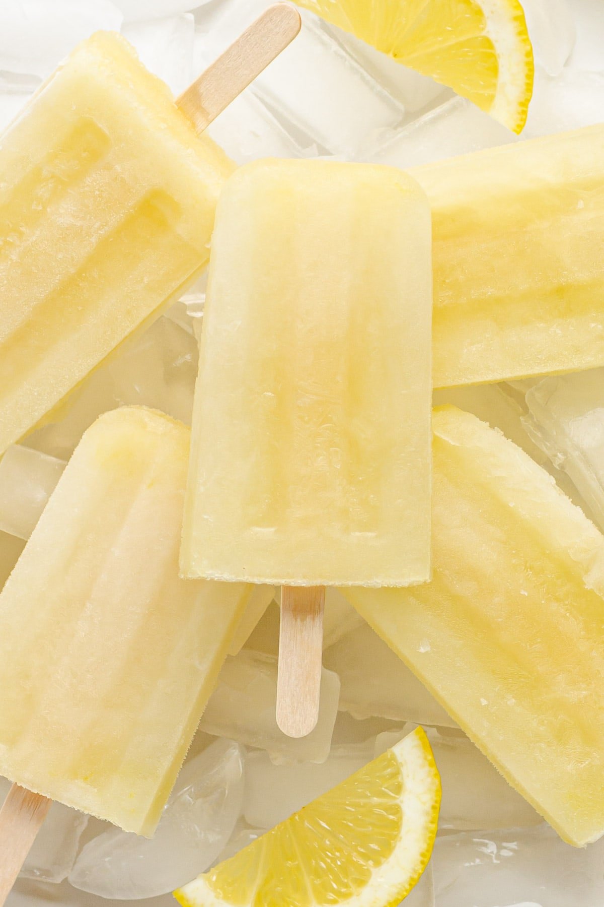 Closeup of lemon popsicles sitting on ice.