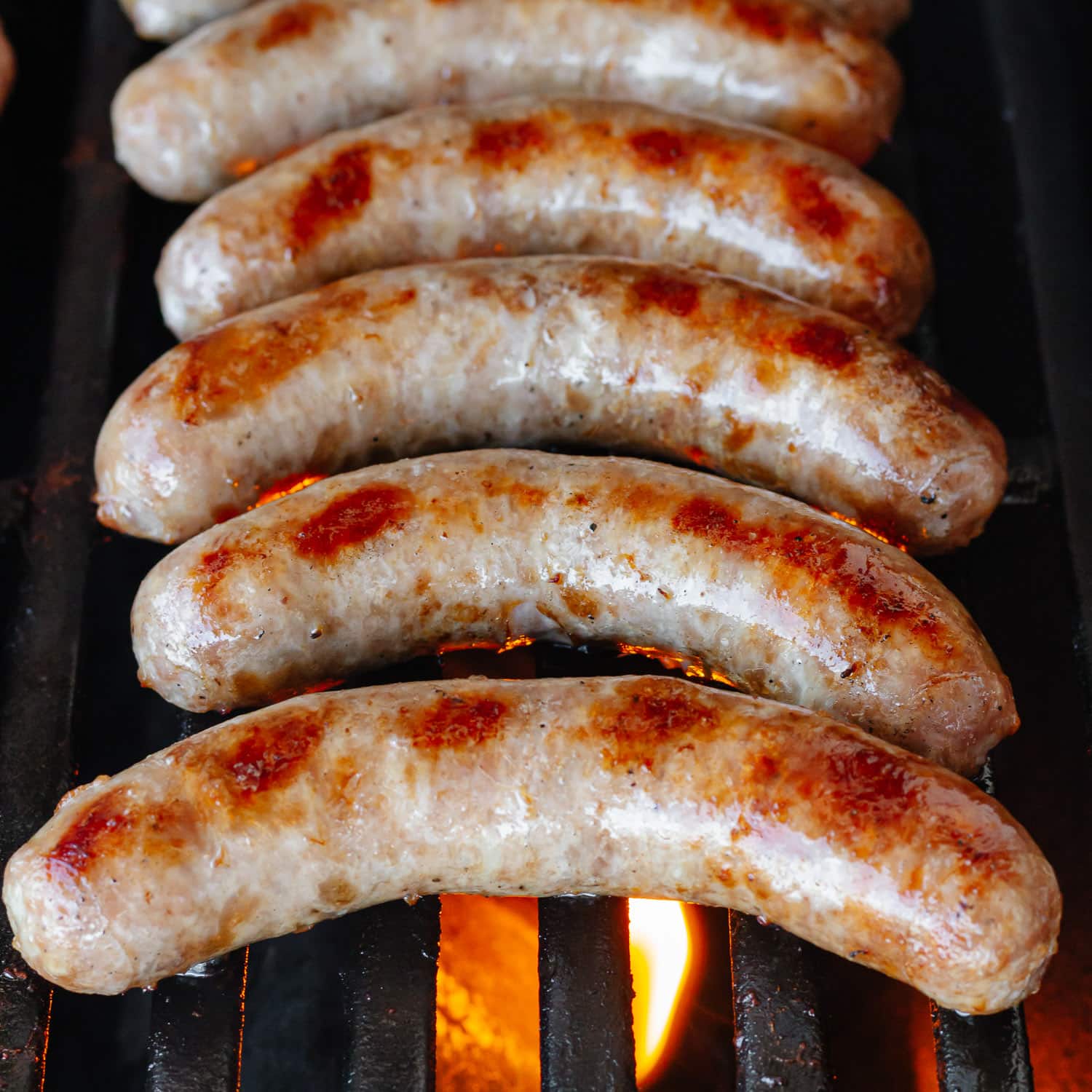 Bratwursts cooking on the grill.