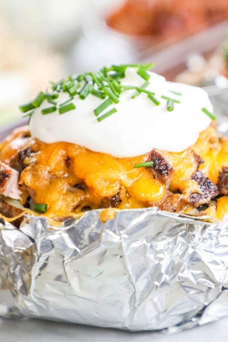 A loaded steak stuffed baked potato in foil.