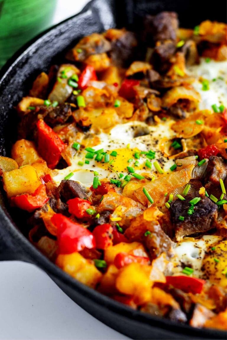 Steak and eggs hash in a cast iron skillet.