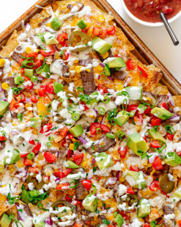 A sheet pan of loaded steak nachos.