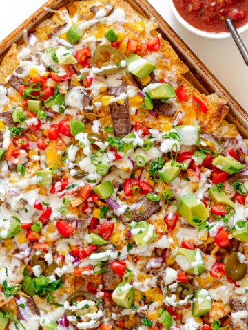 A sheet pan of loaded steak nachos.