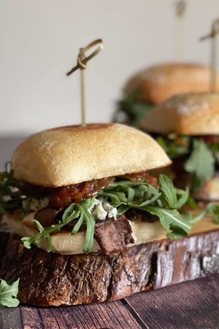 Steak sliders on a wooden plank.