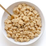 Unbaked butter streusel topping in a white bowl with gold serving spoon.