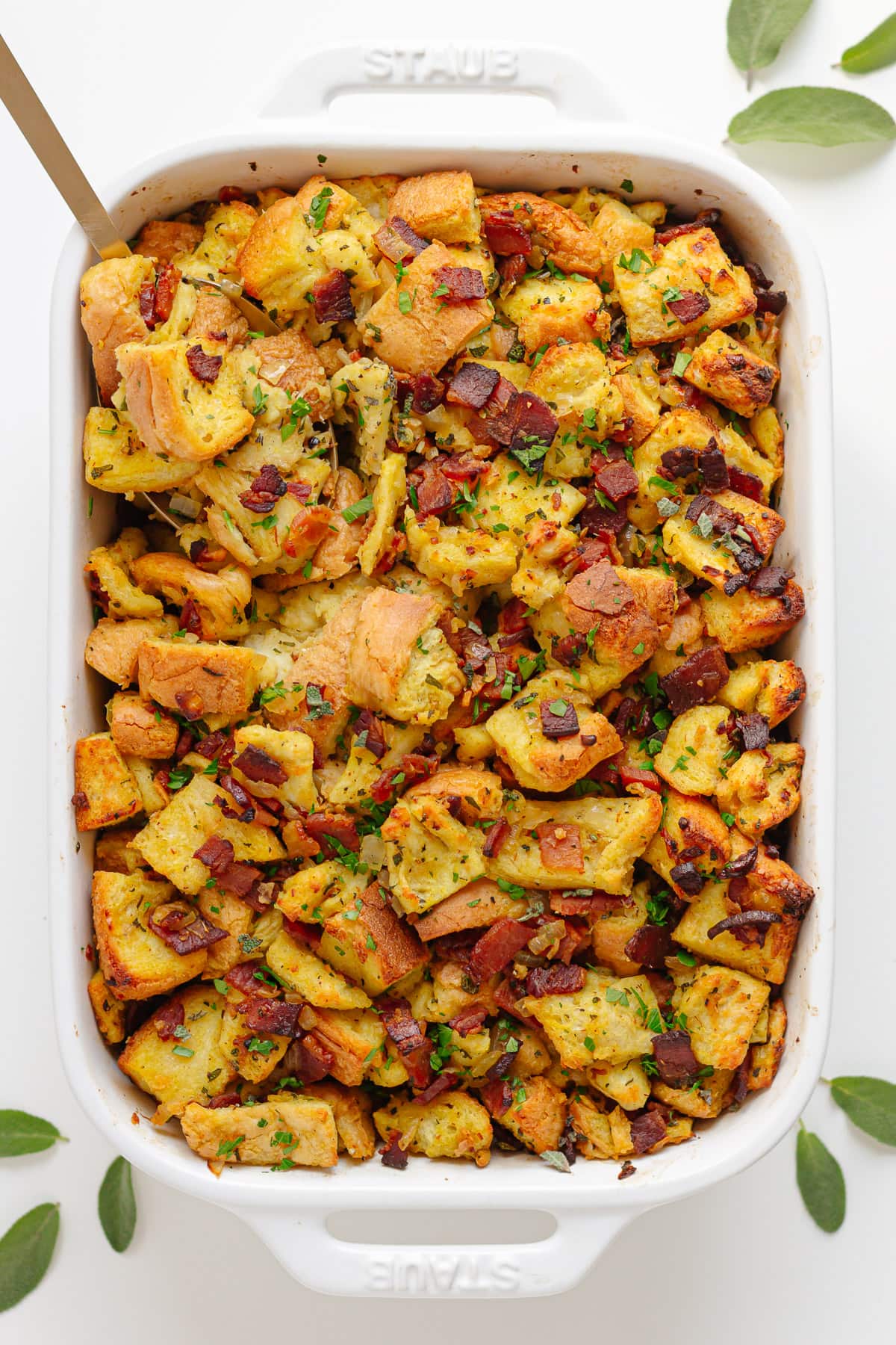 Bacon, sage and onion stuffing in a white casserole dish.