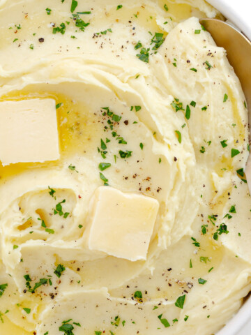 Creamy whipped mashed potatoes in a serving bowl with serving spoon.