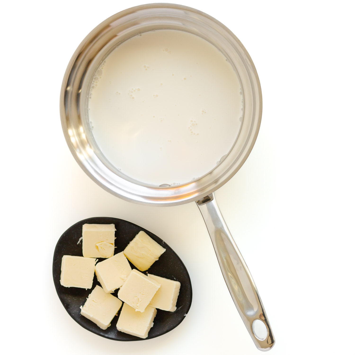 Cream in a small saucepan and diced up butter on small black dish.