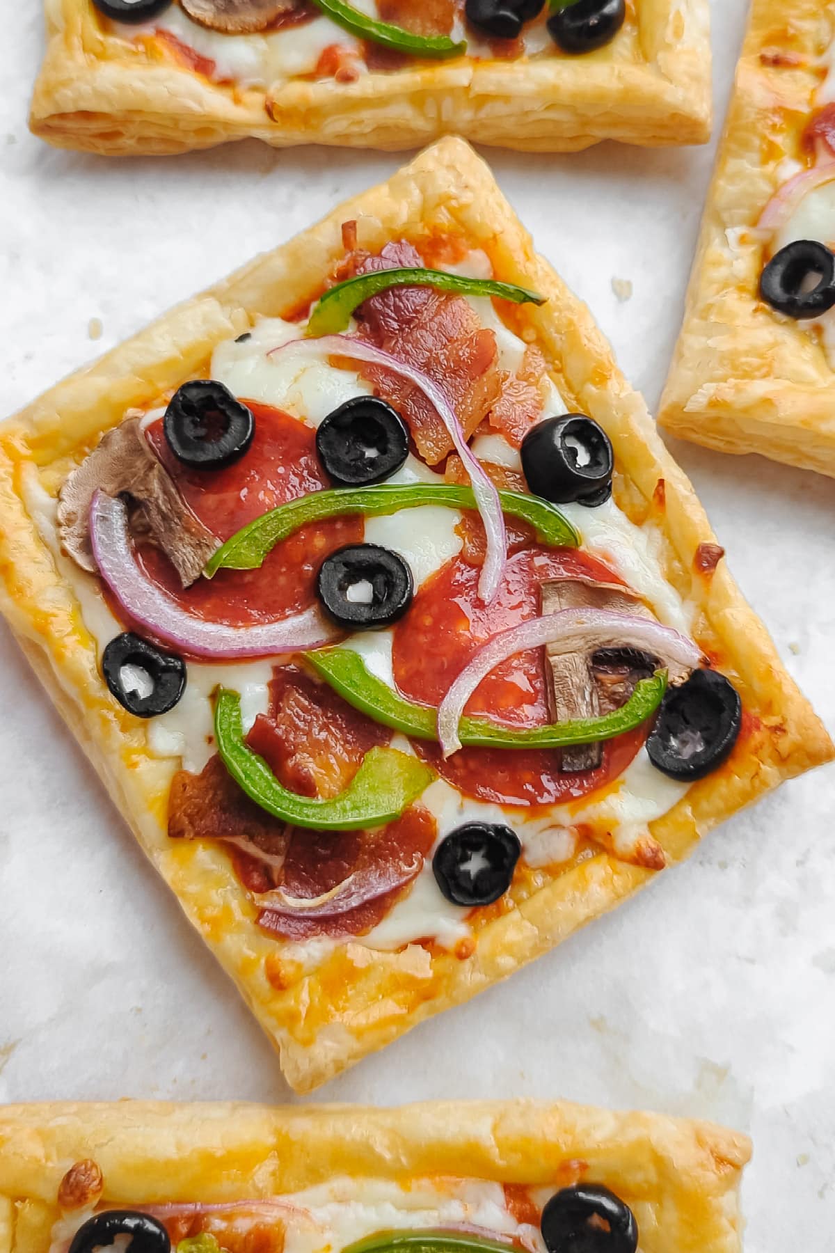 Closeup of supreme puff pastry pizza square.