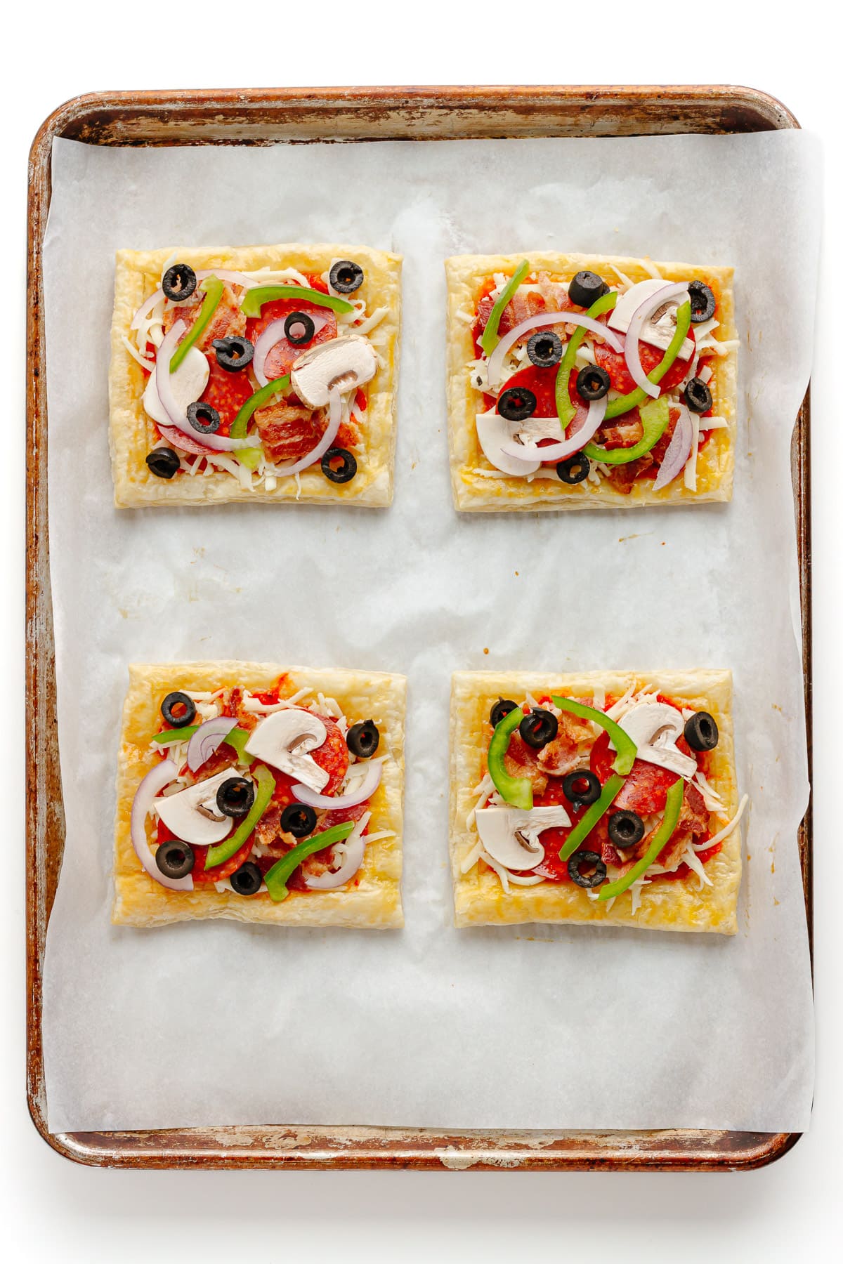 Unbaked puff pastry pizza on a baking sheet.