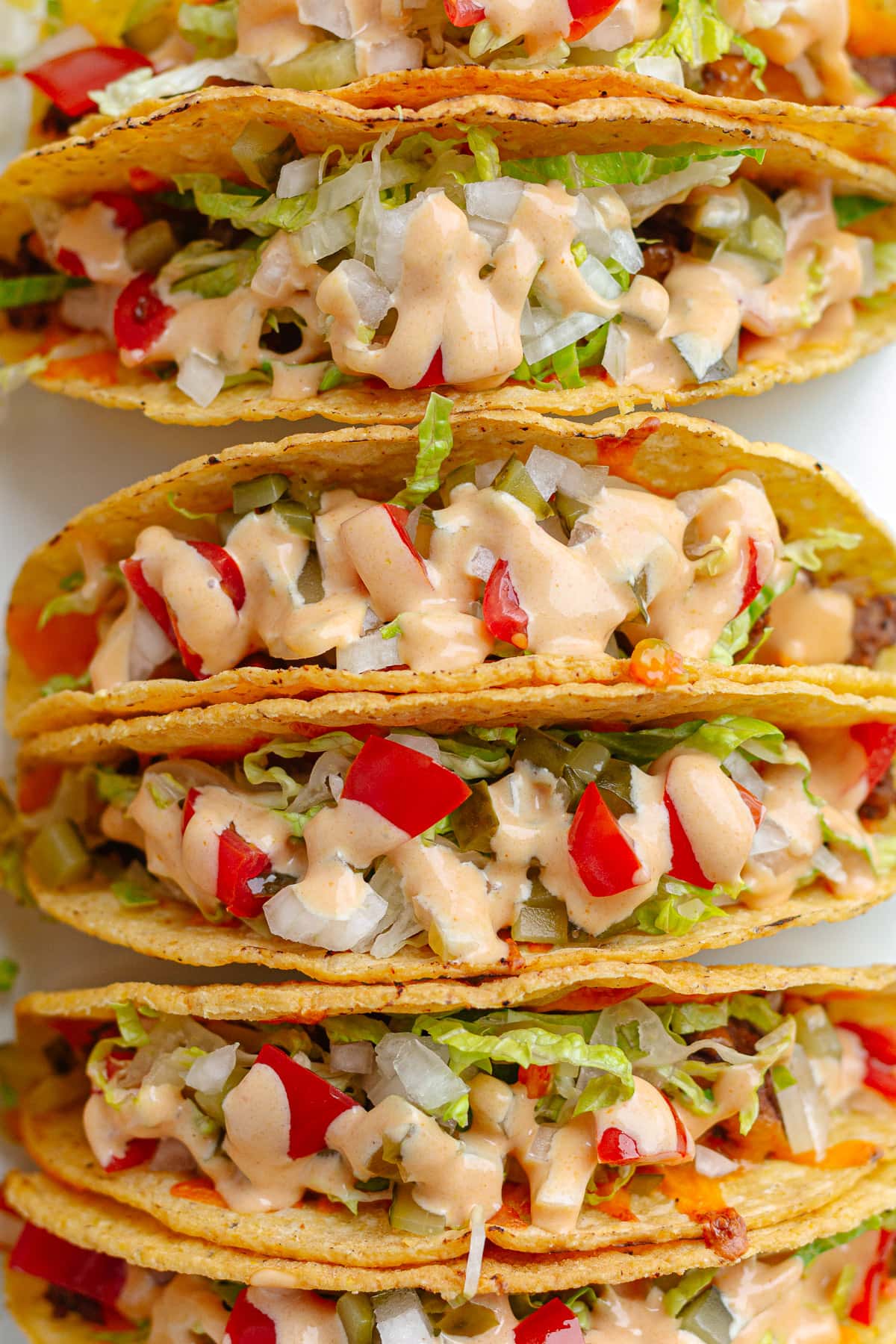 Closeup of the top of baked cheeseburger tacos.