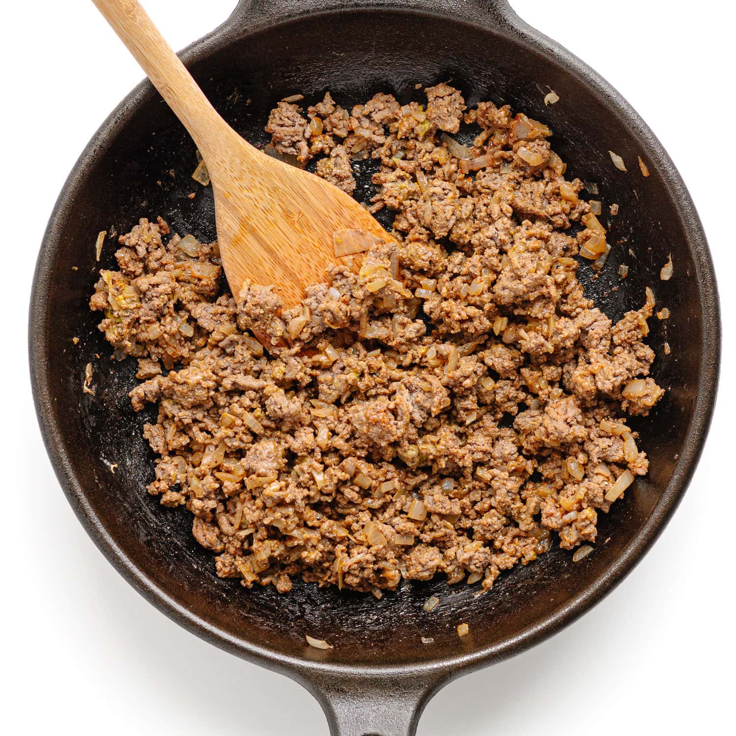 Ground beef mixture for cheeseburger tacos in a cast iron skillet.