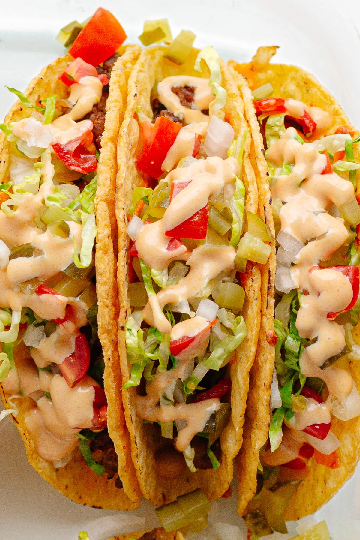 Closeup of three cheeseburger tacos.