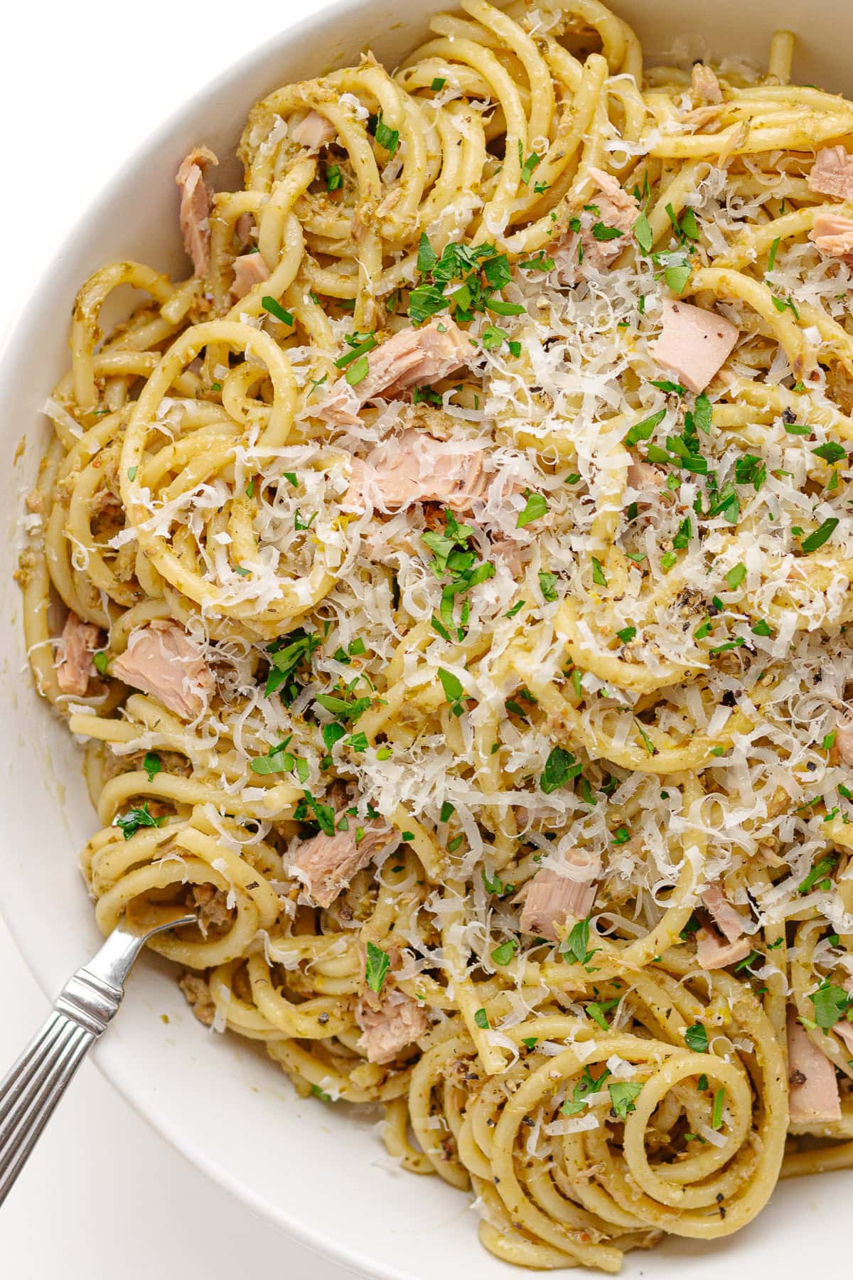 White bowl of tuna pasta with pesto.