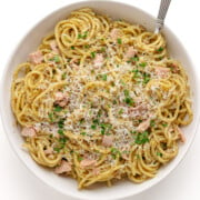 Tuna pesto pasta in a white bowl with fork.