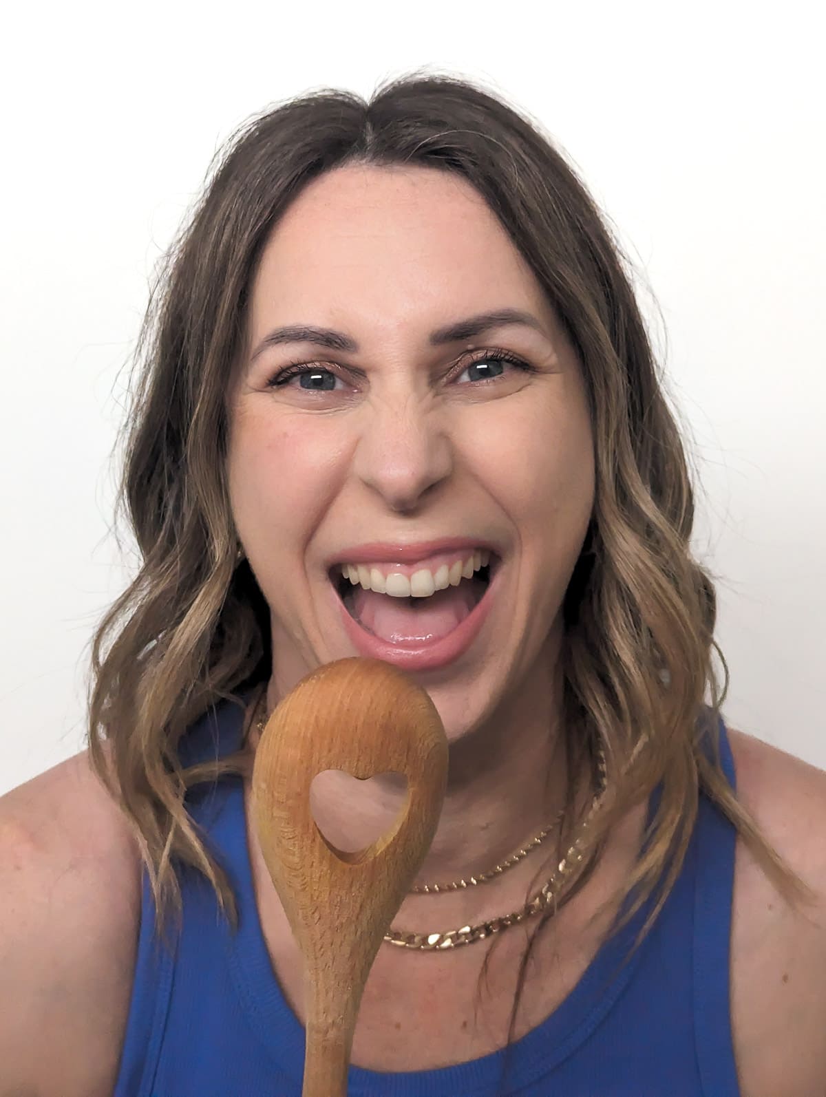 Vanessa Gilic singing into a wooden spoon with heart cut-out.