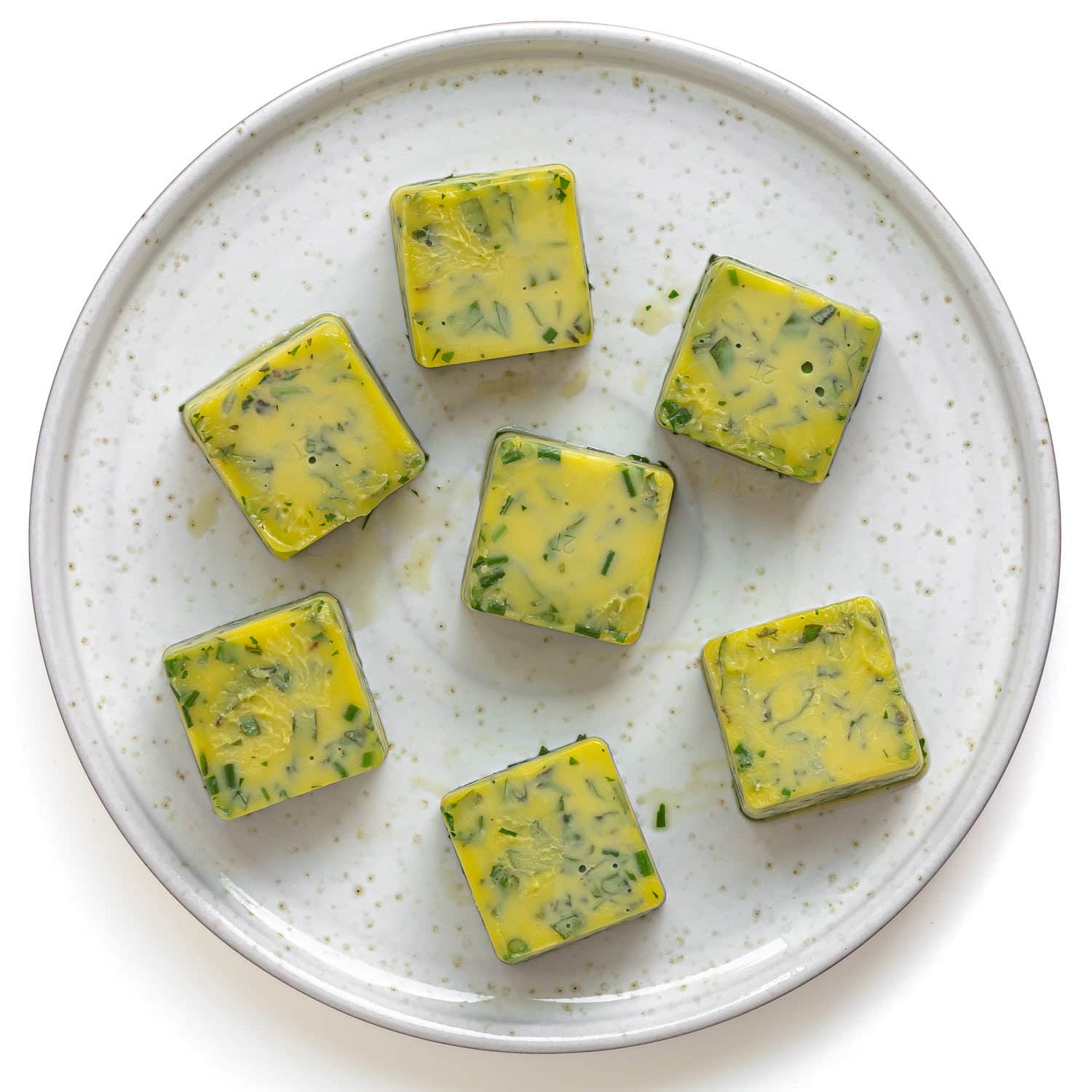 Frozen herb cubes on a plate.