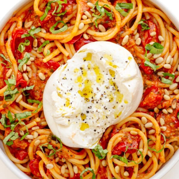 Serving bowl of pasta with cherry tomato sauce and burrata.