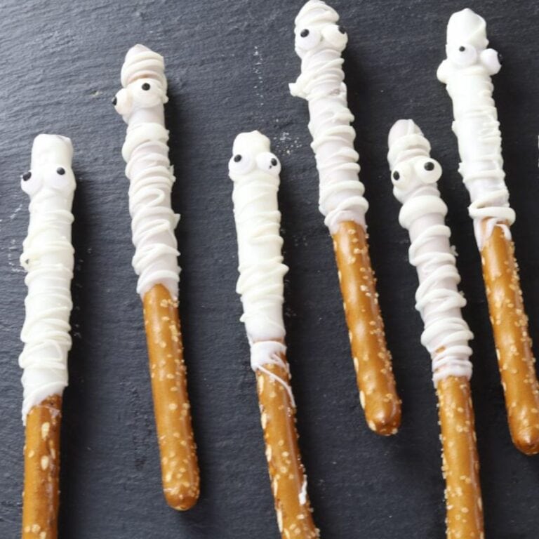 Pretzel sticks drizzled in white chocolate with candy eyeballs to look like mummies.