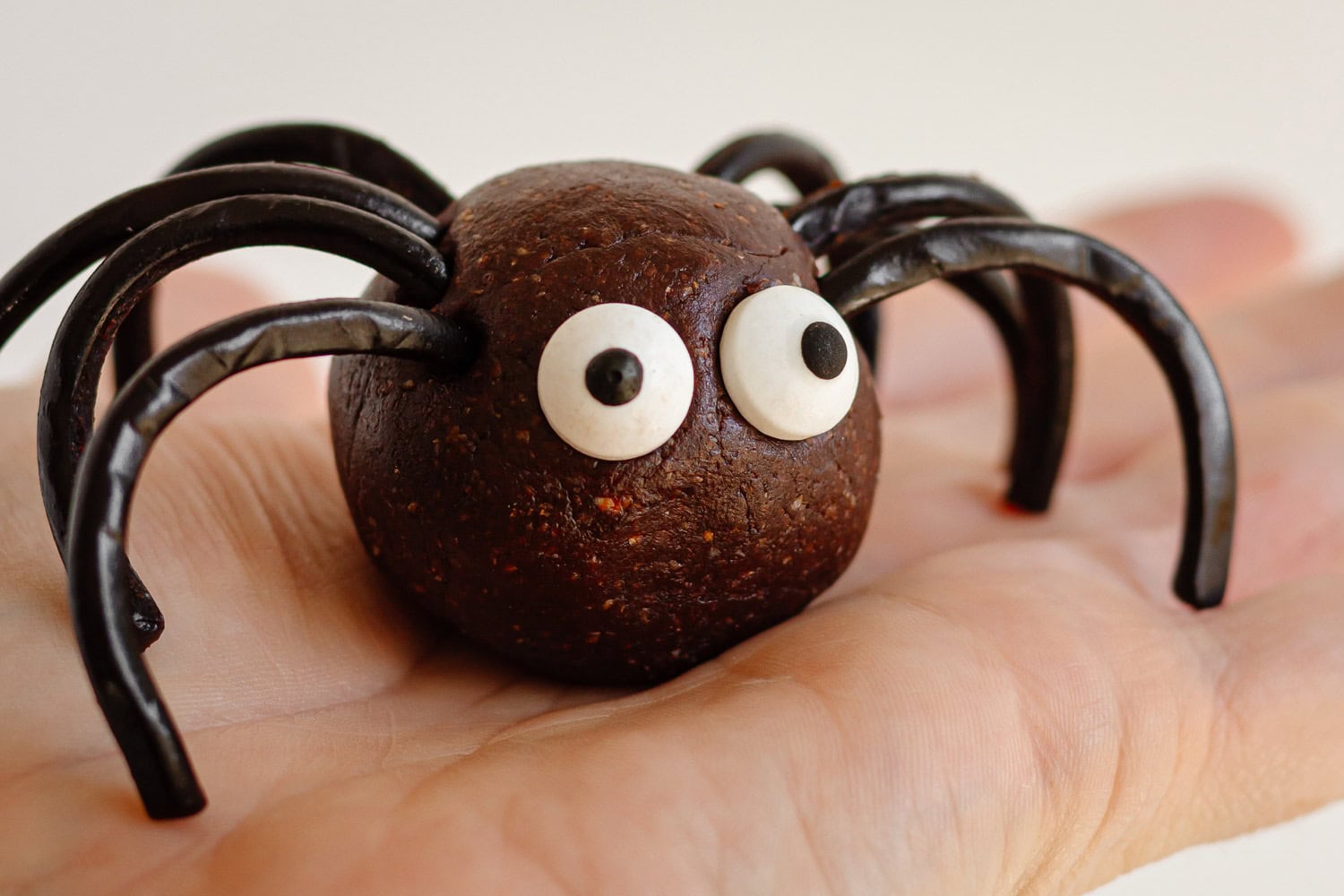 A Halloween spider energy ball sitting on the palm of a hand.
