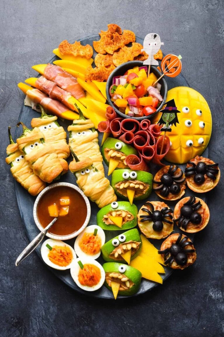 A Halloween snack board filled with a variety of Halloween-themed snacks.