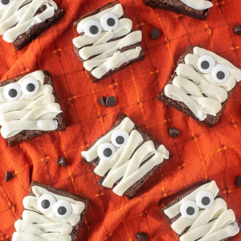 Mummy brownies on an orange table cloth.