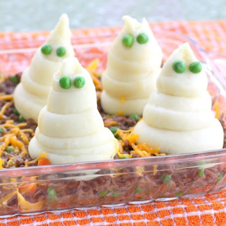 Casserole dish of shepherds pie with mashed potato ghosts on top.