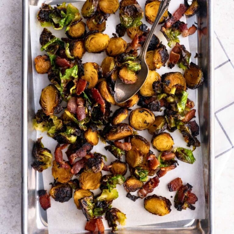 Candied brussels sprouts with bacon on a baking sheet.
