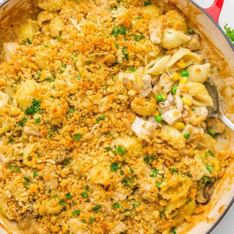 Spoon scooping into turkey pasta casserole with crispy topping.