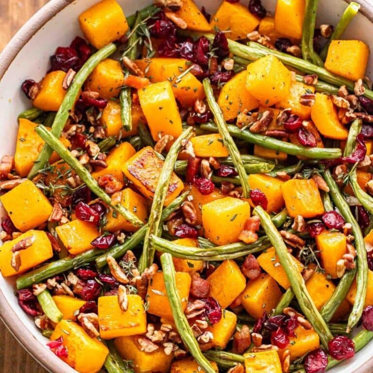 Fall roasted vegetable salad in bowl with butternut squash, green beans, pancetta, dried cranberries and pecans.