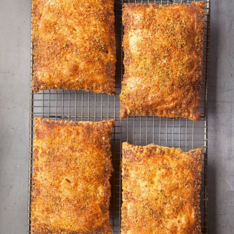 Four turkey puff pastry pockets sitting on a wire cooling rack.