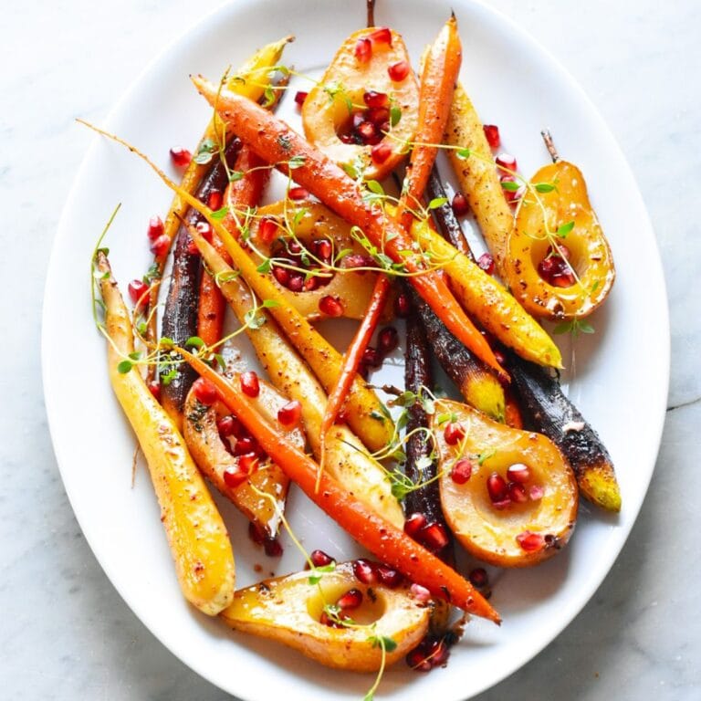 Glazed carrots and pears on a white oval shaped serving platter.