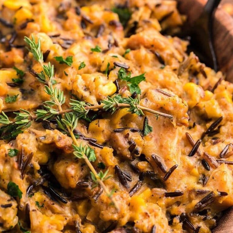 Closeup of turkey wild rice casserole garnished with sprigs of thyme.