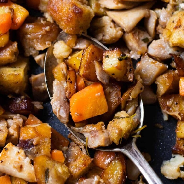 Closeup of spoon scooping up some leftover turkey hash with potatoes and carrots.