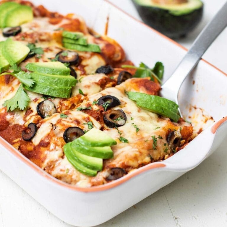 Turkey sweet potato enchiladas in a white casserole dish.
