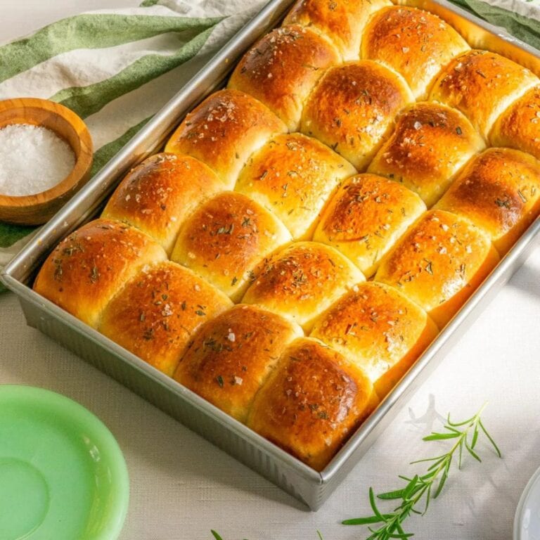 Rosemary sourdough dinner rolls in a baking pan.