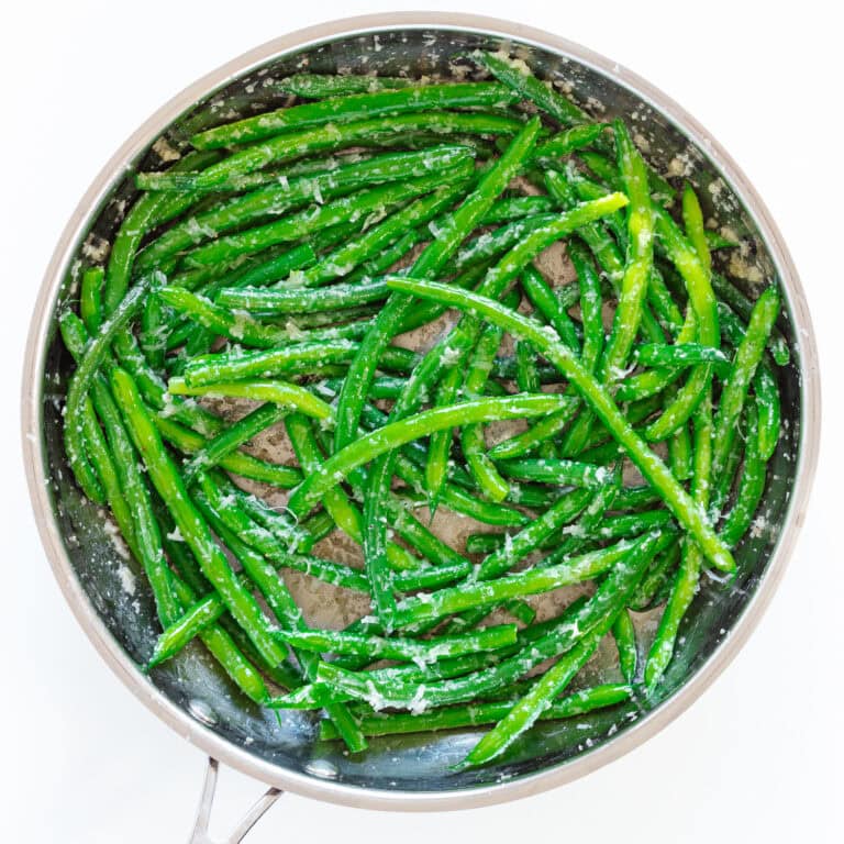Garlic butter green beans in stainless steel skillet.