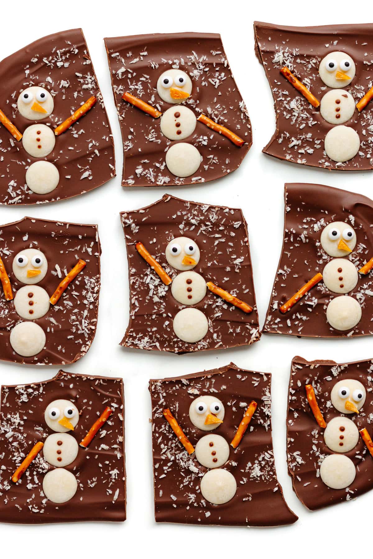 Snowman chocolate bark cut into pieces on a white background.
