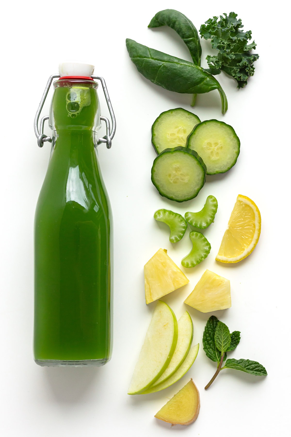 Flip top bottle of green juice next to ingredients that it contains.