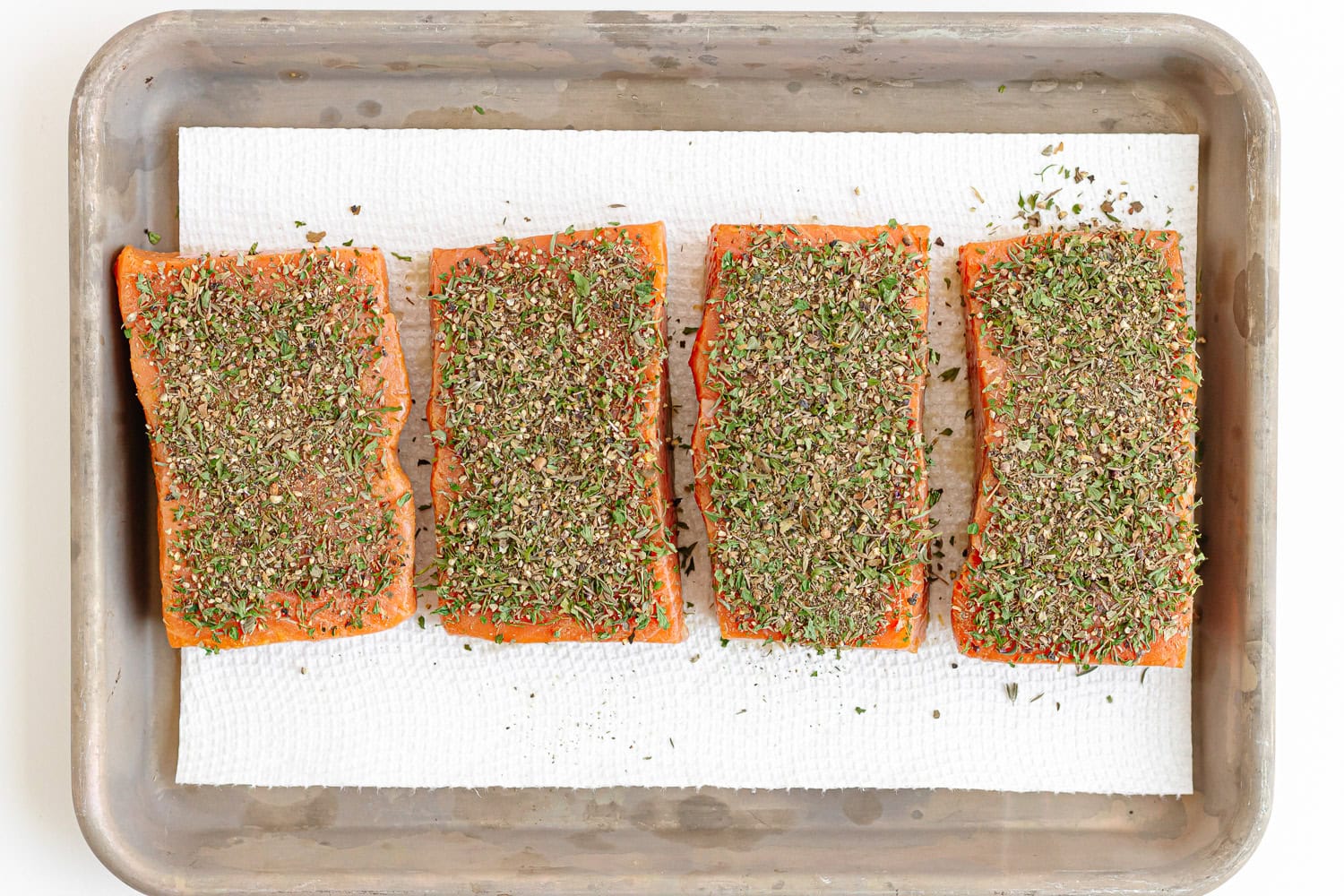 Herb mixture pressed on the tops of four salmon filets.