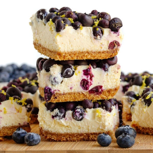Blueberry cheesecake bars on a wooden board.